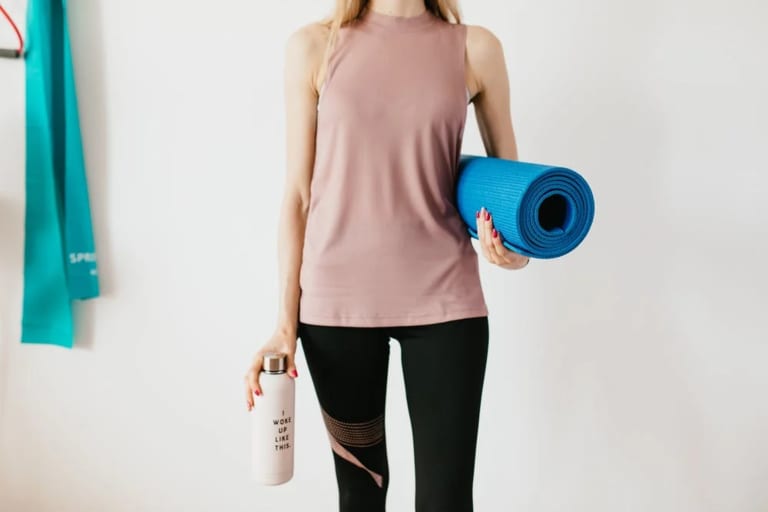 Femme avec tapis de Yoga