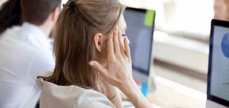 Femme devant son ordinateur se masse les tempes