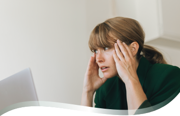 Femme au travail stressée devant son ordinateur