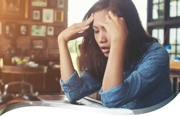 Jeune femme dans un bar épuisée les mains sur la tête